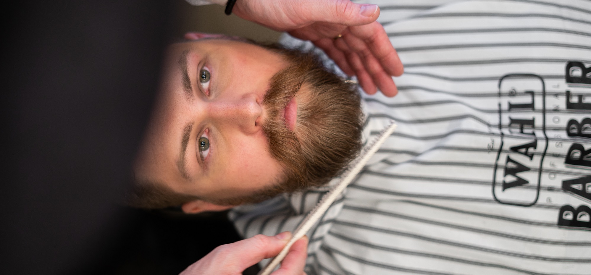 man at barber getting beard brushed